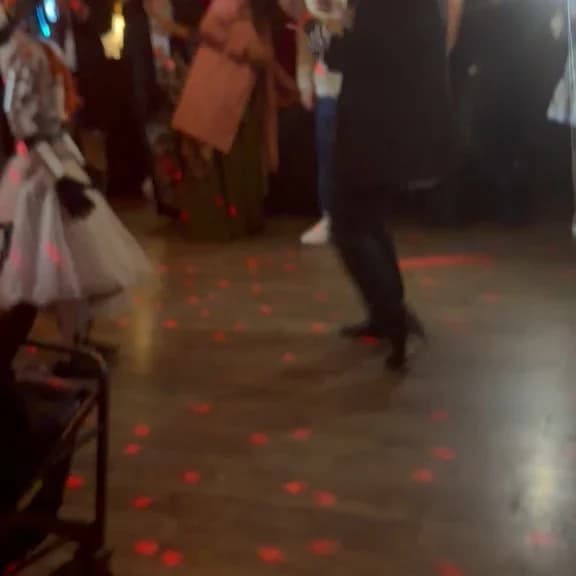 Humanoid robot dancing at a warmly lit event.